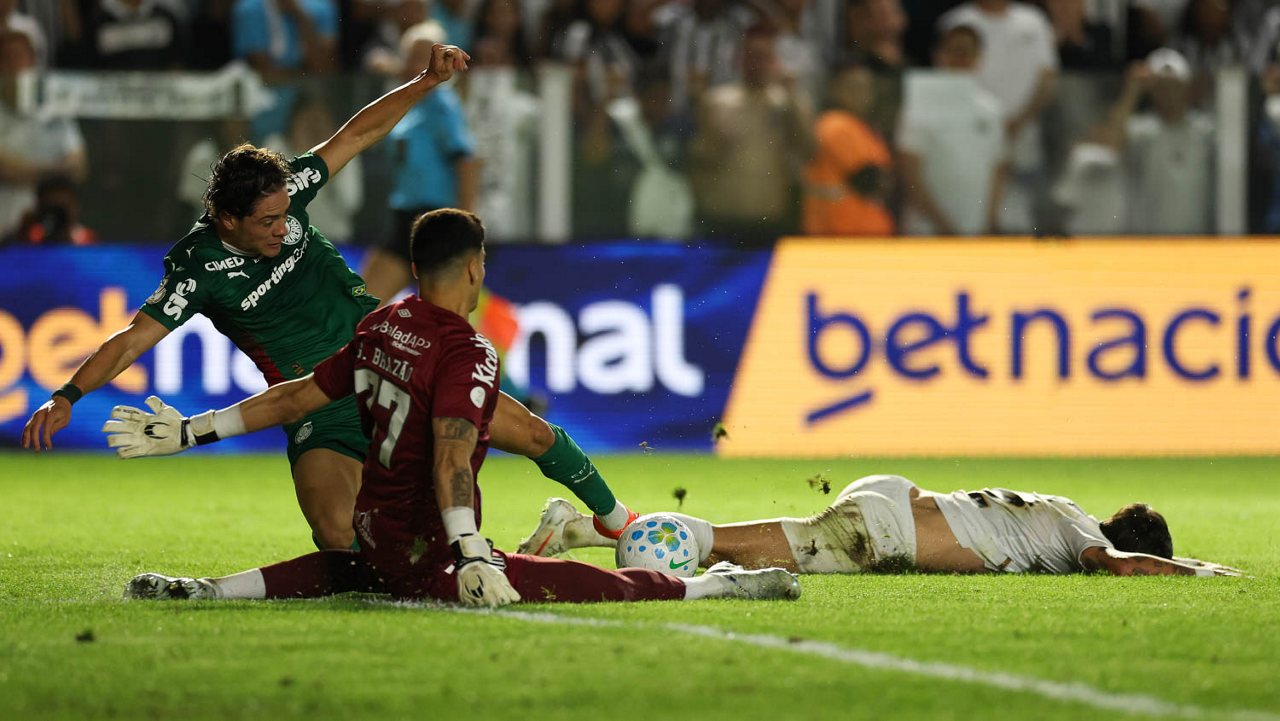 O jogador Agustín Giay, da SE Palmeiras, disputa bola com o jogador do Santos FC, durante partida válida pelas quartas de final, volta, da Copa do Brasil, no Estádio da Vila Belmiro.